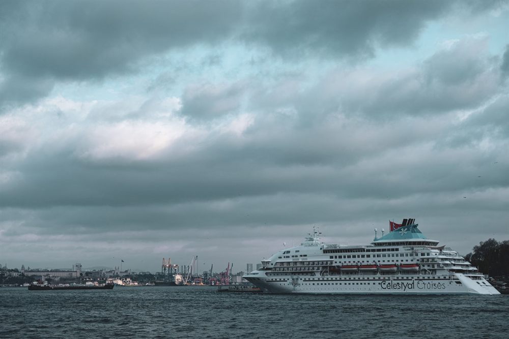 Cruise ship docked at a harbor under a cloudy sky